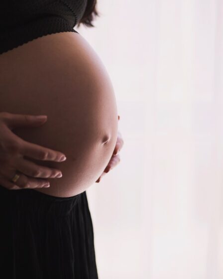 Kobieta w ciąży trzyma się za brzuch